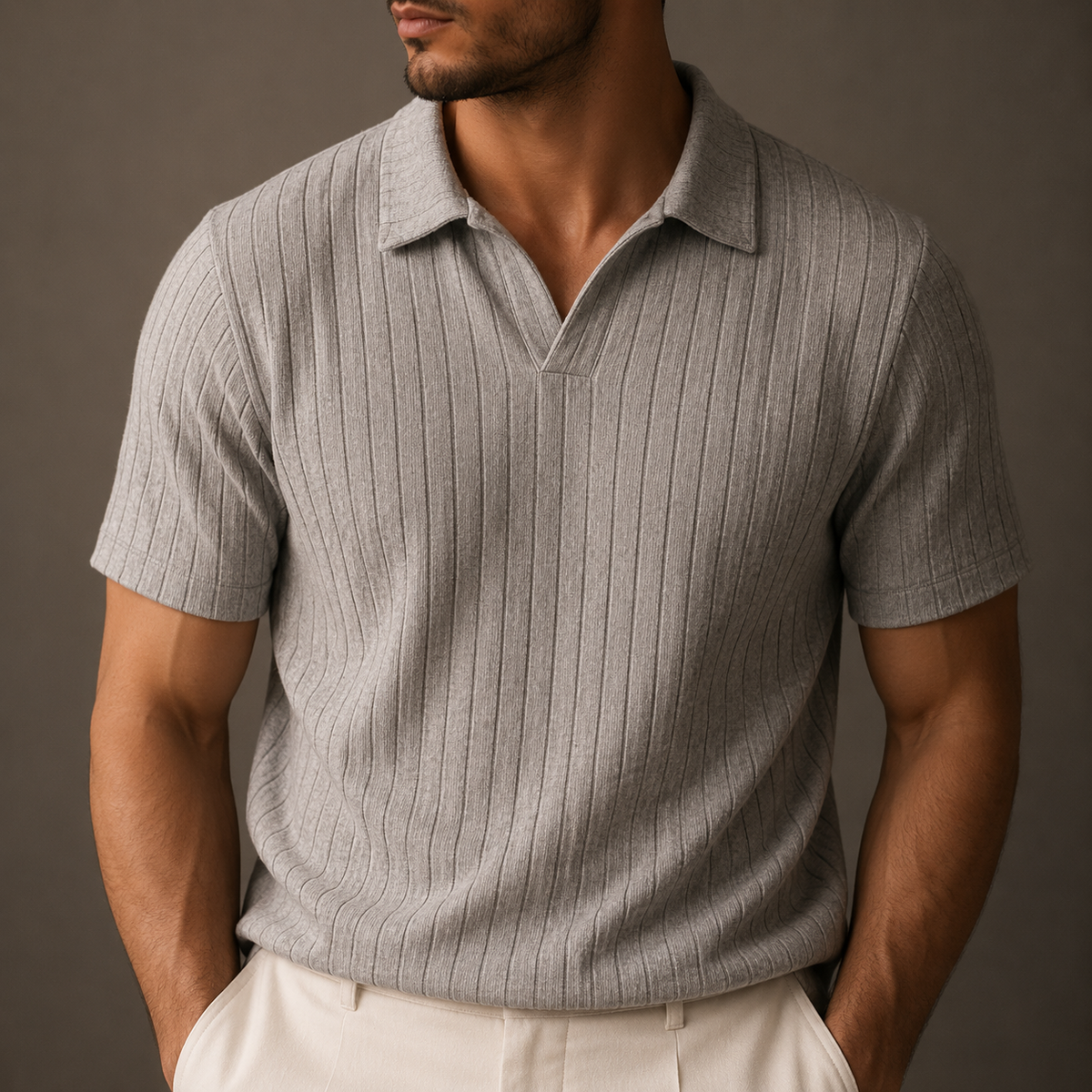 Man wearing a gray ribbed knit polo with an open collar