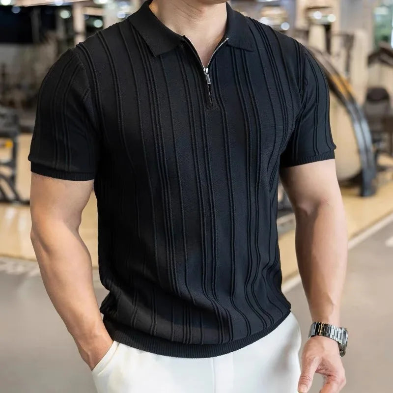 Man wearing a black jacquard zip polo with white trousers