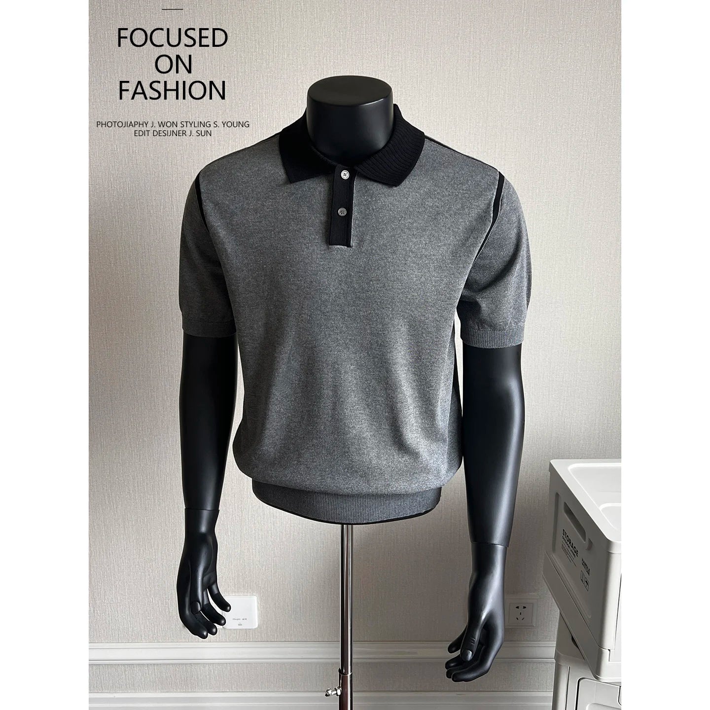 Dark gray knit polo with black contrast collar on a mannequin