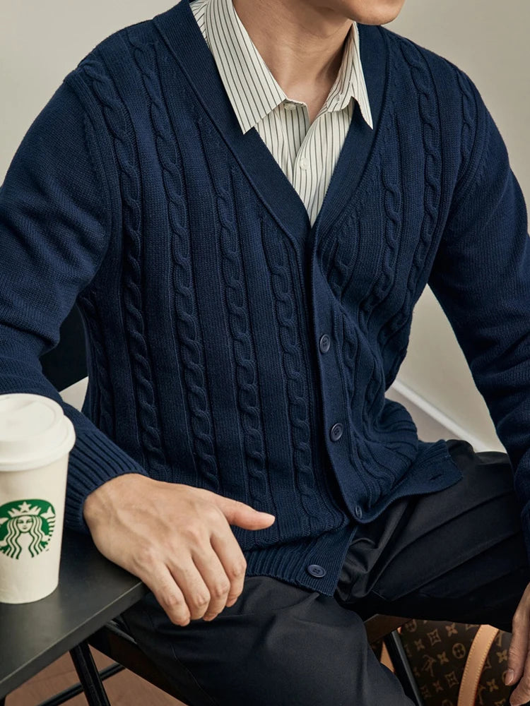 Seated man in a navy cable-knit button-front cardigan