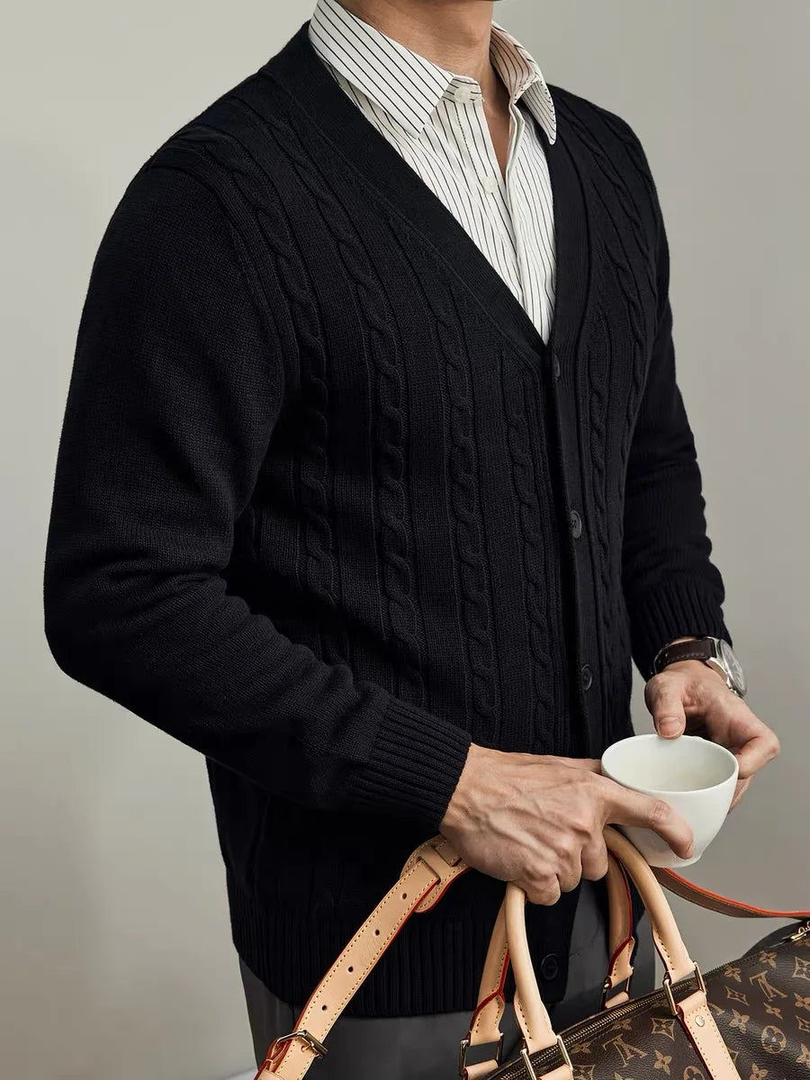 Black cable-knit cardigan styled over a striped shirt