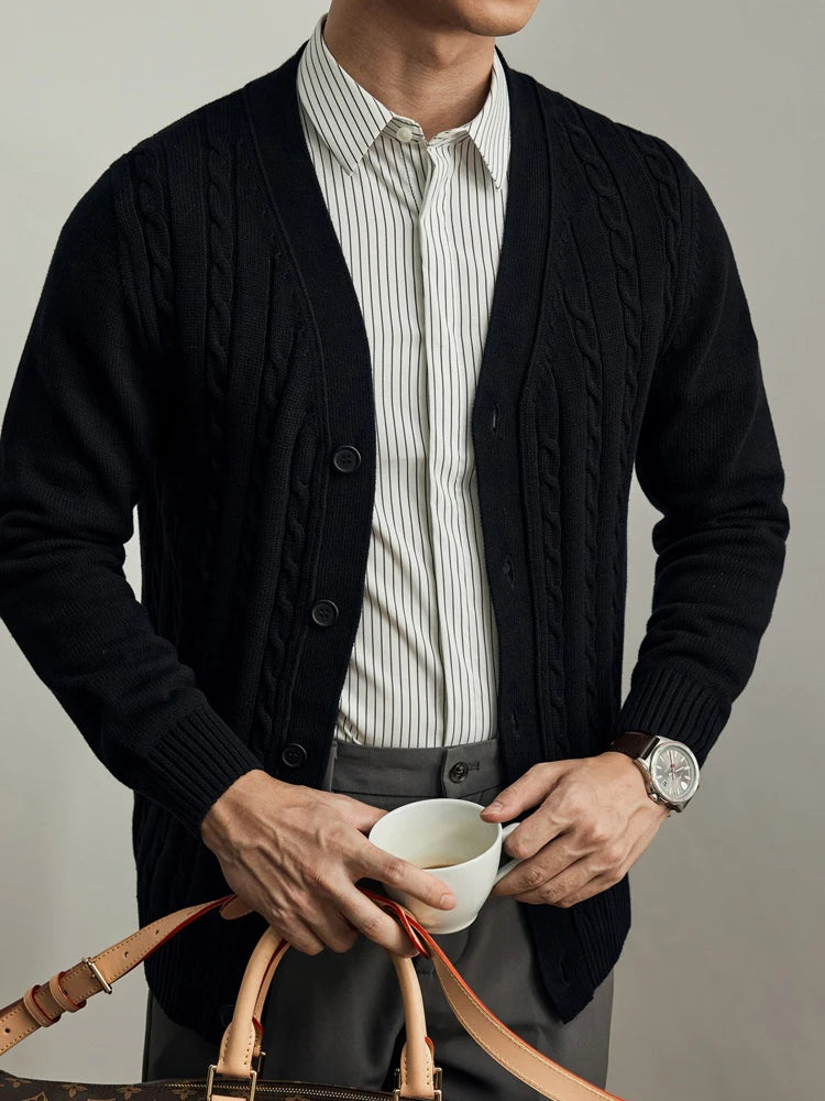 Man wearing a black cable-knit V-neck cardigan with a striped shirt