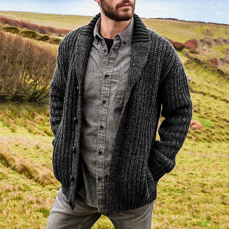 Man wearing a dark-gray shawl-collar cable-knit cardigan outdoors