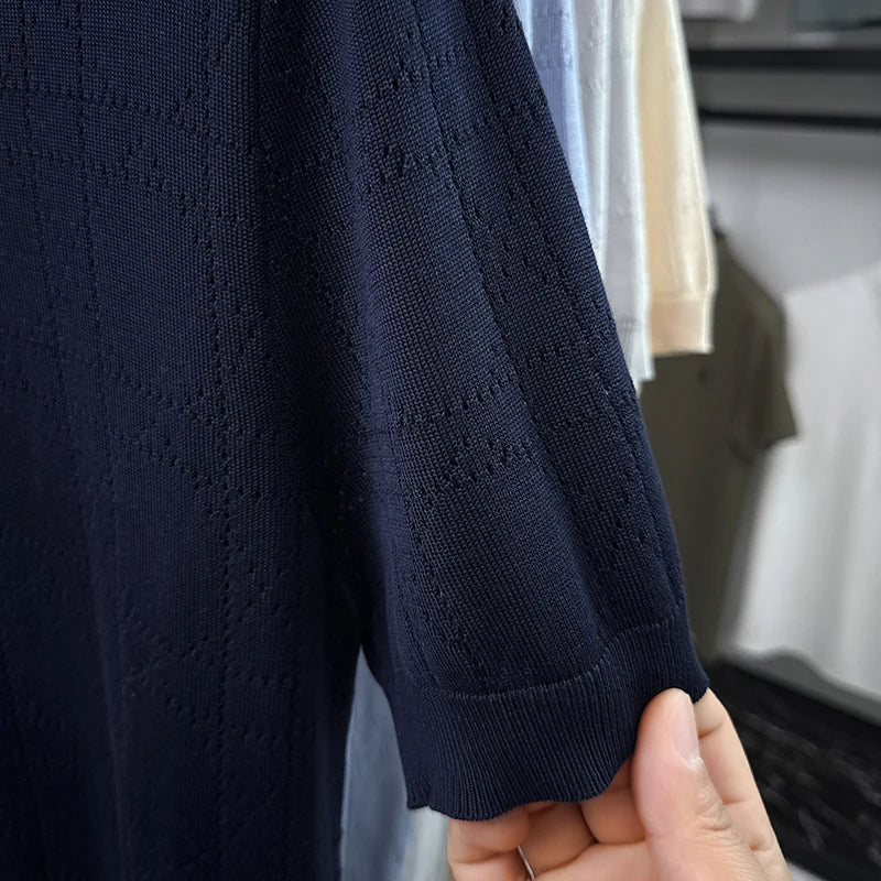 Close-up of the navy open-knit polo sleeve and ribbed cuff