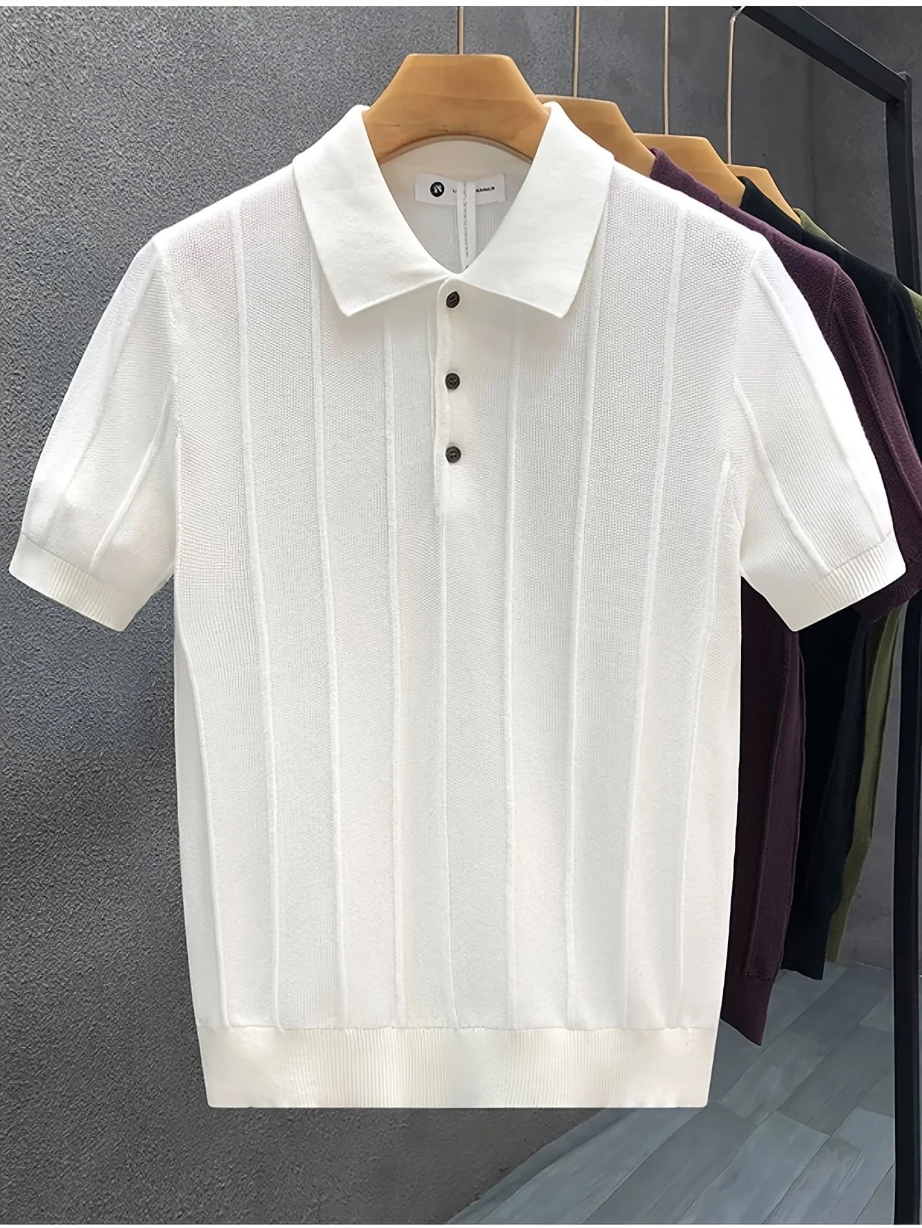 White textured knit polo displayed on a hanger