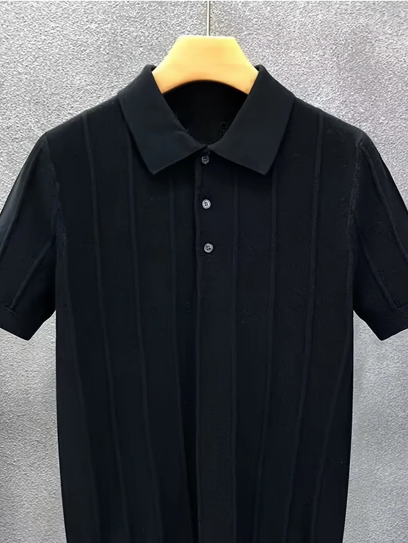 Close-up of the black textured knit polo collar and front